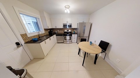 a kitchen with a table and a refrigerator and a sink